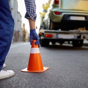 Road worker putting traffic cone on roadside