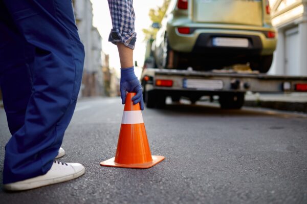 Road worker putting traffic cone on roadside